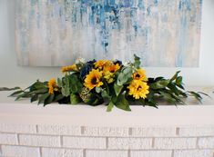 a bunch of flowers sitting on top of a white mantle next to a blue and yellow painting