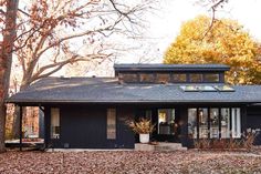 the exterior of a black and white house in autumn