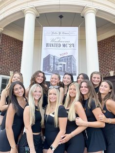 a group of women standing next to each other in front of a building