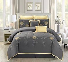 a bed with grey and yellow comforters in a room