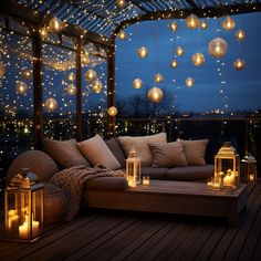 an outdoor seating area with lanterns hanging from the ceiling and candles lit on the floor