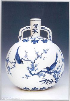 a blue and white vase with two birds on it