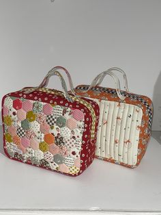 two suitcases sitting on top of a white counter next to each other, one with patchwork