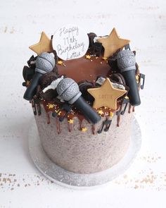 a birthday cake with chocolate frosting and decorations on it's top is decorated with stars