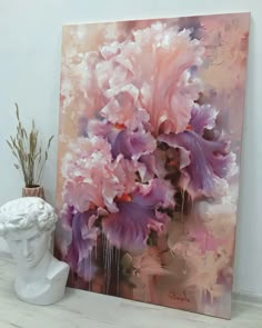 a painting on the wall next to a vase with flowers in it and a white busturine