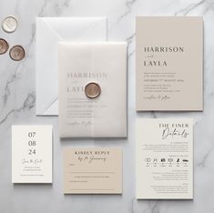 the wedding stationery is laid out on a marble table