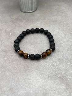 "Elevate your style with our Lava Stone & Tiger Eye Bracelet, featuring luxurious sterling silver spacers. Perfect blend of natural beauty and chic design." Crafted with care and precision, this bracelet features a durable stretch design, ensuring a comfortable fit for all wrist sizes. The 8mm beads are sized for both comfort and impact, making the bracelet substantial yet unobtrusive. This thoughtful design allows for easy wearing and removal, ideal for those who appreciate both style and conve Elegant Lava Stone Beaded Bracelets, Elegant Adjustable Lava Stone Jewelry, Spiritual Black Beaded Bracelets With Stones, Black Bracelets With Natural Stones For Everyday, Elegant Lava Stone Bracelets With Round Beads, Elegant Lava Stone Bracelet With Round Beads, Spiritual Black Bracelets With Stones, Elegant Black Lava Stone Beaded Bracelets, Silver Lava Stone Beaded Bracelets With 8mm Beads