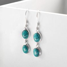 Our stunning Turquoise Double Oval Earrings are  a perfect addition to any outfit. Turquoise is perhaps the oldest stone in human history. The talisman of kings, shamens and warriors. It is a stone of protection, strong and opaque yet soothing to the touch, healing to the eye. Among the Ancient Egyptians, Persians and Chinese, Aztecs and Incas of South America, and Native North Americans, Turquoise was sacred in its adornment and for power, luck, and protection. The delicate veining or mottled webbing in cream or brown is inherent to the stone and serves to enhance its character. All Martha Jackson jewellery comes complete with a gift box and blank gift card for you to write a short message on Made from: Sterling silver and turquoise Dimensions: Oval 1.1cm x 0.7cm. Overall length 4cm Oval Earrings, Ancient Egyptians, Climber Earrings, Oval Earring, Human History, Dangly Earrings, Pearl Gemstone, Spiritual Jewelry, Silver Turquoise