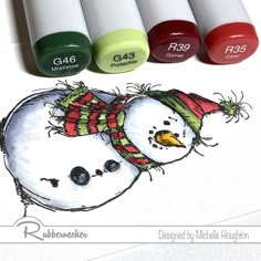 three markers with snowmen on them next to some crayons and marker pens