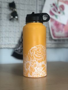 a yellow water bottle sitting on top of a wooden table