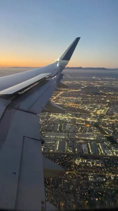 the wing of an airplane flying over a city at night