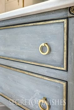 a blue dresser with gold handles and knobs on the drawers is shown in this image