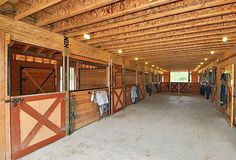 the inside of a horse barn with stalls and stalls