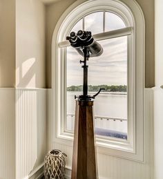 a lamp sitting on top of a wooden table next to a window in a room