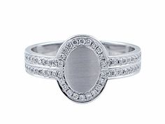 a white gold ring with diamonds on the sides and an oval stone in the center