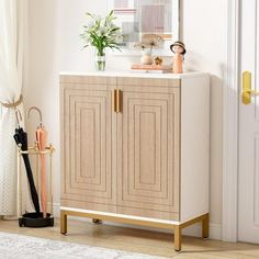 a white and gold cabinet in a room with a mirror on the wall above it