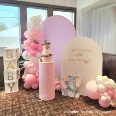 a baby shower is set up with balloons and cake on the table for it's first birthday