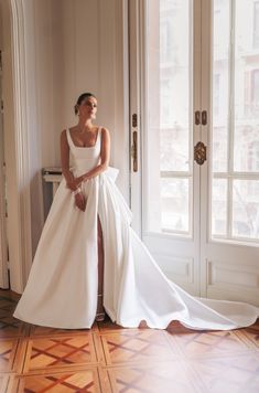 a woman in a white wedding dress sitting on the floor