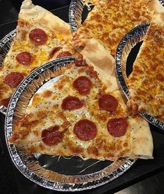 three slices of pepperoni pizza on tin plates