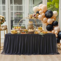 a table topped with lots of desserts and balloons