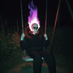 a skeleton sitting on a swing in the dark with purple flames coming out of it