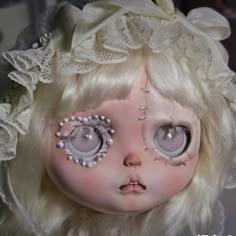 a close up of a doll's face with eyeballs and lace on it