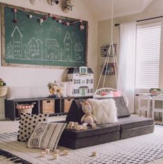 a child's room with toys and chalkboard on the wall, including a sofa