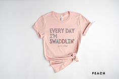 a pink t - shirt that says every day i'm swadlin