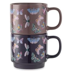 two coffee mugs with butterflies on them, one is brown and the other is blue