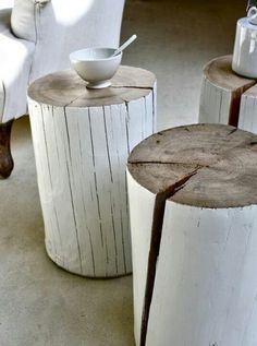 three wooden stools made out of logs with one white bowl on top and the other brown