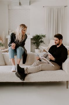 a man and woman sitting on a white couch