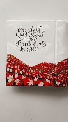 an open book with red and white flowers on it