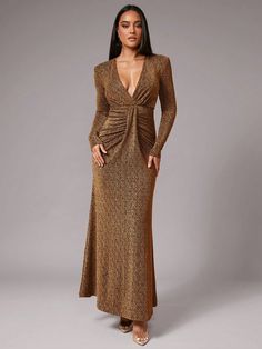 a woman wearing a gold dress with long sleeves and a deep v - neckline