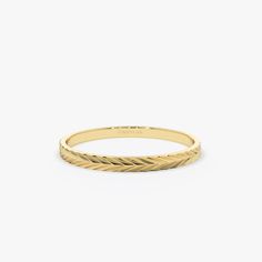 a yellow gold ring with an intricate design on the front and sides, set against a white background