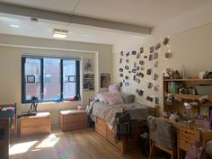 a bedroom with wooden floors and lots of clutter on the wall next to it