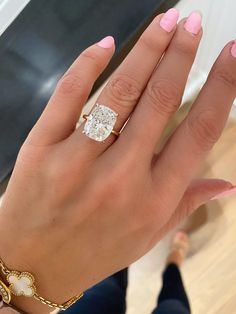 a woman's hand with pink manicures and a diamond ring