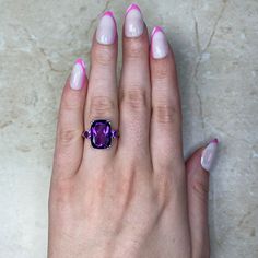 The Nassau ring features an elongated cushion-cut amethyst that is accented by two amethysts on either side. The 14k yellow gold mounting features a scroll motif on the gallery and diamonds along the shoulders.
The center amethyst is 14mm x 10mm and weighs 6.07 carats. The diamonds have a total carat weight of 0.05 carats.
This ring can be resized to any finger size at no extra cost.
If you have any questions about the Nassau ring, please feel free to contact us. Luxury Purple Rectangular Amethyst Ring, Luxury Purple Amethyst Rectangular Ring, Luxury Purple Amethyst Ring, Rectangular Shape, Luxury Rectangular Amethyst Ring, Fine Jewelry Cushion Cut Amethyst Ring, Fine Jewelry Purple Cushion Cut Amethyst Ring, Cushion Cut Amethyst Ring In Purple, Cushion Cut Purple Amethyst Ring, Rectangular Purple Amethyst Ring