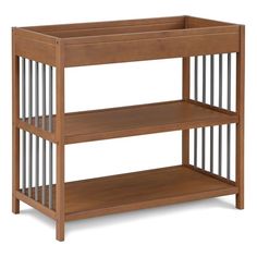 a wooden baby crib with two shelves on the bottom and one shelf below it