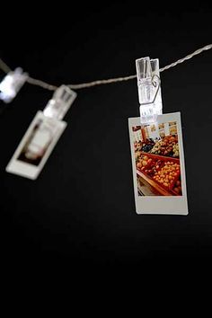 an old photo hanging on a string with lights