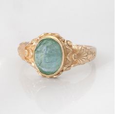 This vintage style sea-themed signet ring, featuring beautiful little shells and ocean-inspired fluorishes all around the center which displays a lovely bright green peridot or sea-blue aquamarine cabochon.  (NOTE: Please SELECT and state in the order notes the stone you prefer in the listing!) This ring can be customized with any letter or word (provided it fits) and is made in solid gold. This ring can be made for men or women and in your preferred size or color of gold. A phrase or letter may Aesthetic Vintage Rings, Vintage Adjustable Emerald Ring, Vintage Engraved Cabochon Ring As Gift, Vintage Engraved Ring With Birthstone, Vintage Oval Engraved Emerald Ring, Handmade Vintage Green Signet Ring, Vintage Oval Emerald Ring Engraved, Vintage Handmade Green Signet Ring, Sea Ring