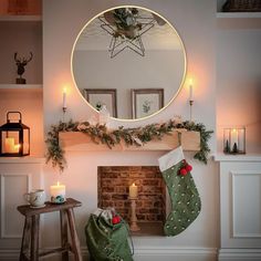 a christmas fireplace decorated with stockings and candles