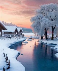 a snowy scene with trees and water in the foreground, houses on the other side