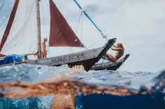 a man swimming in the ocean next to a boat