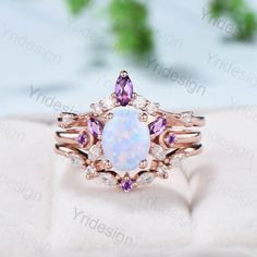 an opal and diamond ring on top of a white cloth