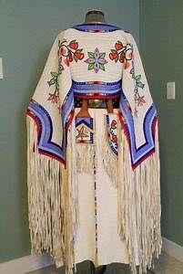 a woman's shawl with fringes and beads on it, in front of a blue wall