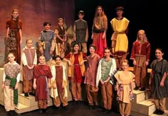 a group of children standing on steps in front of a stage