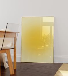 an empty room with a chair, table and large yellow painting on the wall behind it