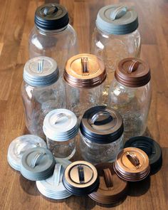 there are many glass jars with lids on the table