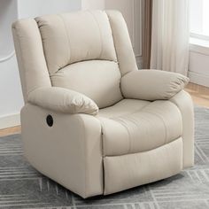 a white recliner chair sitting on top of a rug in front of a window