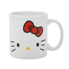 a white hello kitty mug with a red bow on it's head and eyes